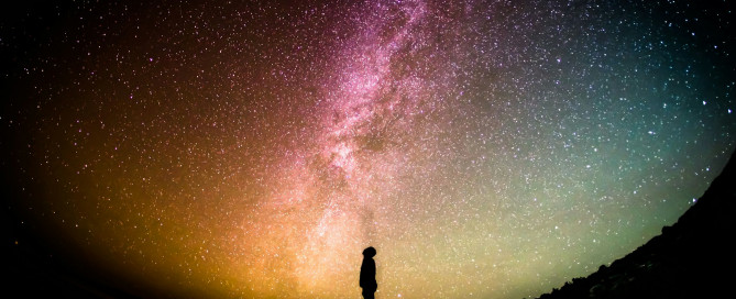 Silhouetted person staring up at Milky Way